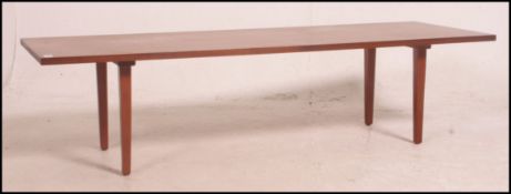 A 1970's retro teak rectangular danish coffee table raised on squared supports with rectangular