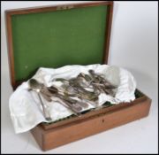 An Edwardian oak canteen of cutlery being baize lined together with loose cutlery believed to be