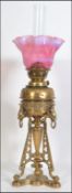 A stunning early 20th century brass oil lamp in the Art Nouveau manner being raised on a tripod