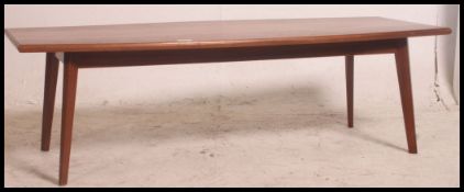 A vintage 1970's Danish influenced teak coffee table of rectangular form having tapered legs with
