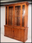 A good 20th century pine dresser with upper section enclosed by two glazed doors having adjustable