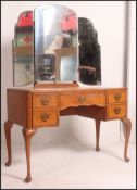 A 1930's Queen Anne walnut dressing table raised on cabriole legs with pad feet having a series of