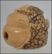 A Japanese netsuke in the form of a salamander holding a snail.