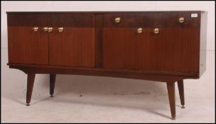 A vintage retro dresser sideboard being raised on angled legs with fall front cupboard,