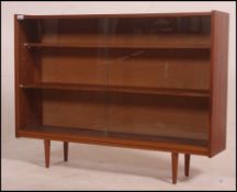A vintage 1970's Danish Influence teak mid century bookcase / shelving unit with glass sliding