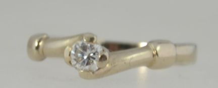 An 18ct white gold ladies single stone ring having buckle style shoulders. The stone approx pnts.