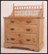 A late Victorian tile back pine wash stand / chest having three graduating long drawers with drop