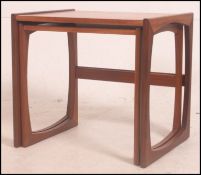 A 1970's G-Plan Kelso retro nest of tables in teak raised on shaped legs united by stretchers,