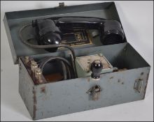 A mid 20th century Field Telephone in metal case with carry handle atop by MFG Co Ltd london dated