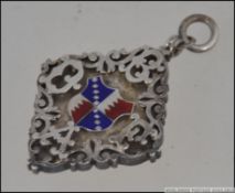 A stunning silver and enamel armorial pendent of heavy form in diamond shape with embellished