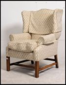 A mid century Georgian revival Chesterfield armchair raised on squared legs united by stretchers