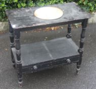 A Victorian ebonised aesthetic movement washbowl stand table raised on turned legs with central