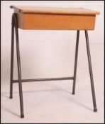 A mid century 1950's school desk with hinged desk top in beech all raised on tubular metal frame.