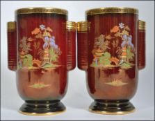 A pair of 1930's Crown Devon Fieldings decorative vases, rouge colour with twin handles,