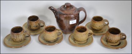 A Roger Cockram stoneware 6 person tea service to include 6 cups and saucers and a teapot.