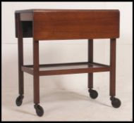 A 1930's vintage two tier oak tea trolley raised on castors along with a vintage stool of similar