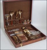 A cased canteen of cutlery containing a bronze and wooden studded handles,