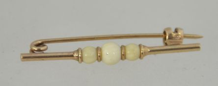 A early 20th century 9ct gold bar brooch with ivory ball styling with clip c clasp. Measures 3.3cms.
