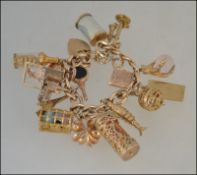A 9ct gold hallmarked charm bracelet, with a collection of 16 9ct hallmarked gold charms,