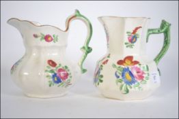 A 19th century Swansea Dillwyn ceramic near matching pair of jugs with floral spray.