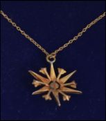 A 9ct gold seed pearl necklace in the form of a snowflake 3.