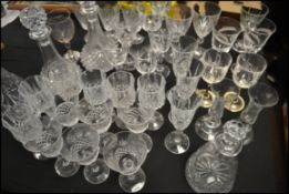 A large collection of cut glass crystal glasses and decanters to include wine glasses, tumblers,