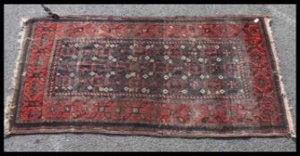 A Baluch rug of Minah Kani design having a red and blue ground with geometric decoration etc.