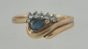 A 9ct gold, sapphire and diamond ladies ring. The teardrop sapphire surrounded by .