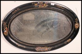 A late Victorian ebonised and chinoserie painted oval wall mirror with central bevelled mirror