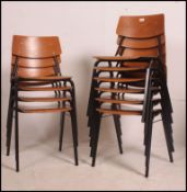 A stack of 10 mid 20th century school chairs being raised on ebonised tubular metal supports with