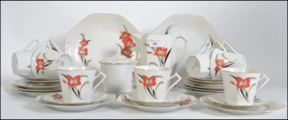 An art deco style be China tea service having hand painted floral designs and consisting of cups,