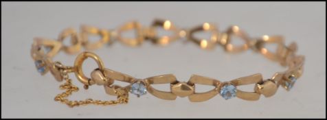 A 9ct gold ( stamped 375 ) braclet 19cm being linked together with 9 bow shaped links and each bow