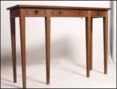 A Regency style blond walnut console / hall table being raised on turned and tapering legs with a