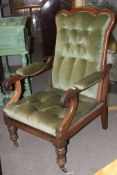 A Victorian mahogany reclining library armchair being raised on turned legs with green velour seat