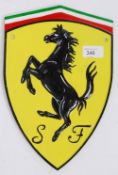 A reproduction metal Ferrari emblem advertising sign, with raised painted notation. 30cm tall.