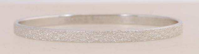 A signed vintage silver tone bangle with