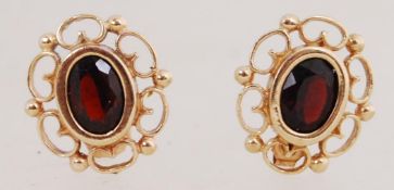 A pair of 9ct gold earrings set with gar
