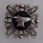 A vintage white metal brooch pin with Ib