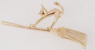 A gold tone metal vintage brooch of a ca