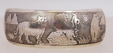 A vintage white metal bangle with tiger