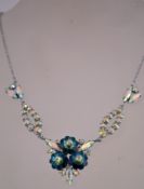 A 1980s rhinestone necklace in a silver tone metal setting with aroura rhinestones and flower