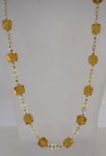 A 1920s flapper necklace with clear and topaz glass beads, measuring 109cms long.