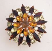 A large 1960s starburst cluster brooch in a gold tone setting with a rollover clasp,