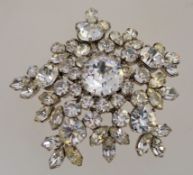 A large 1950s to 1960s rhinestone cluster brooch in a silver tone metal setting with a rollover