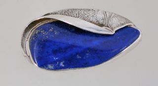 A large silver and lapis lazuli brooch with a roll over clasp, marked 