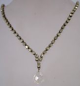 A 1950s rhinestone necklace with crystal drop in a brass metal setting with a bolt ring clasp,