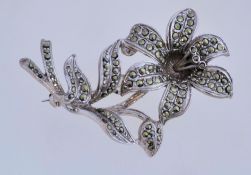 A 1950s marcasite brooch in silver tone metal with a rollover clasp, measuring 6cms long.