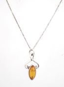 A silver and amber pendant on a chain,
