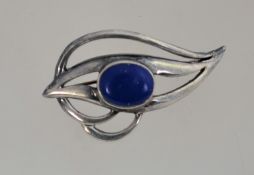 A silver and lapis lazuli brooch in the form of a stylised eye,
