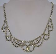 A 1950s rhinestone necklace in a silver tone metal setting with a fold over clasp measuring 39.